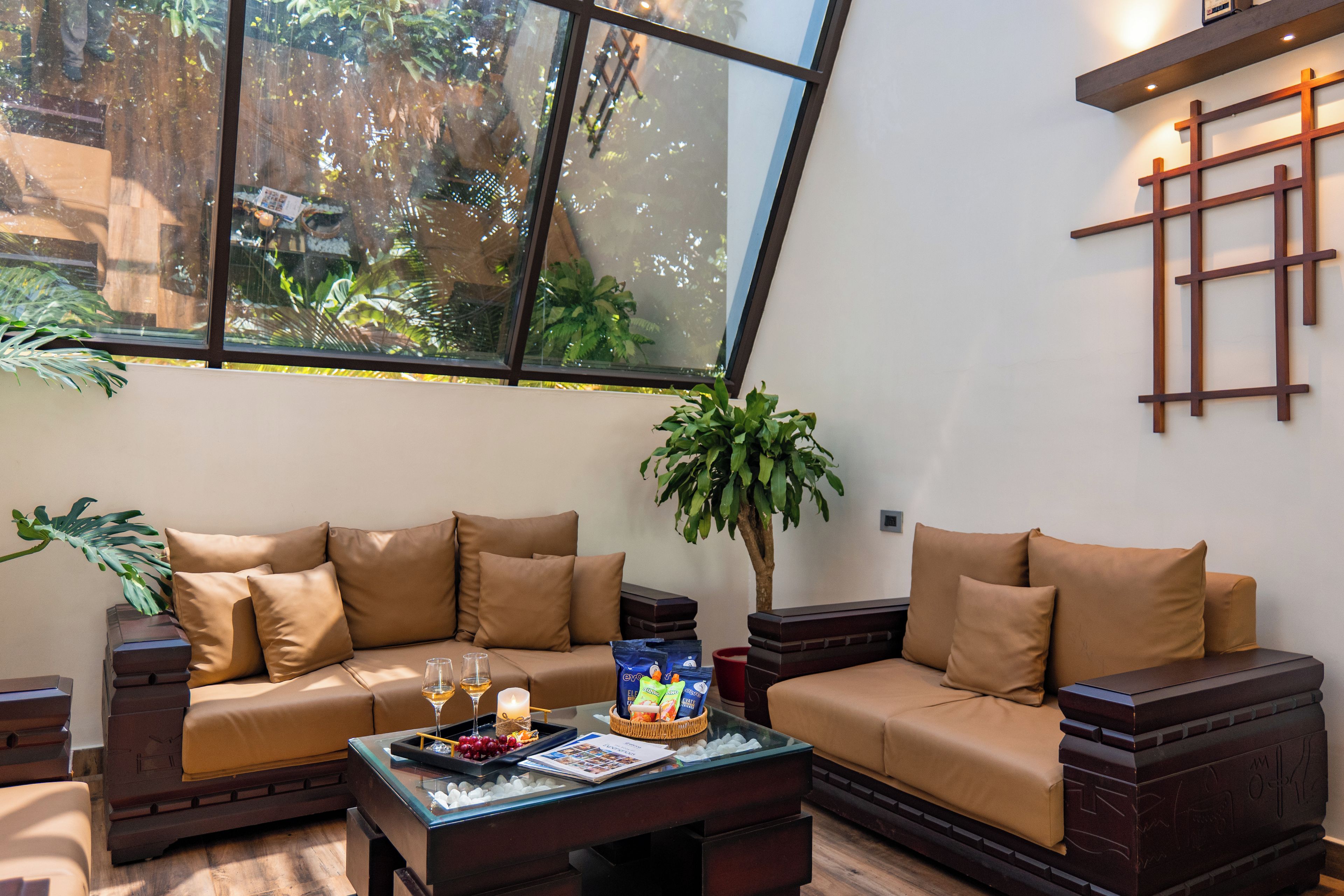 Un salón moderno con sofá, una mesa de centro y un ventanal con vistas a la vegetación.