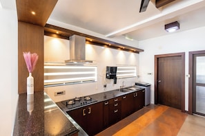 A modern kitchen with a central island, built-in oven, and stainless steel appliances.