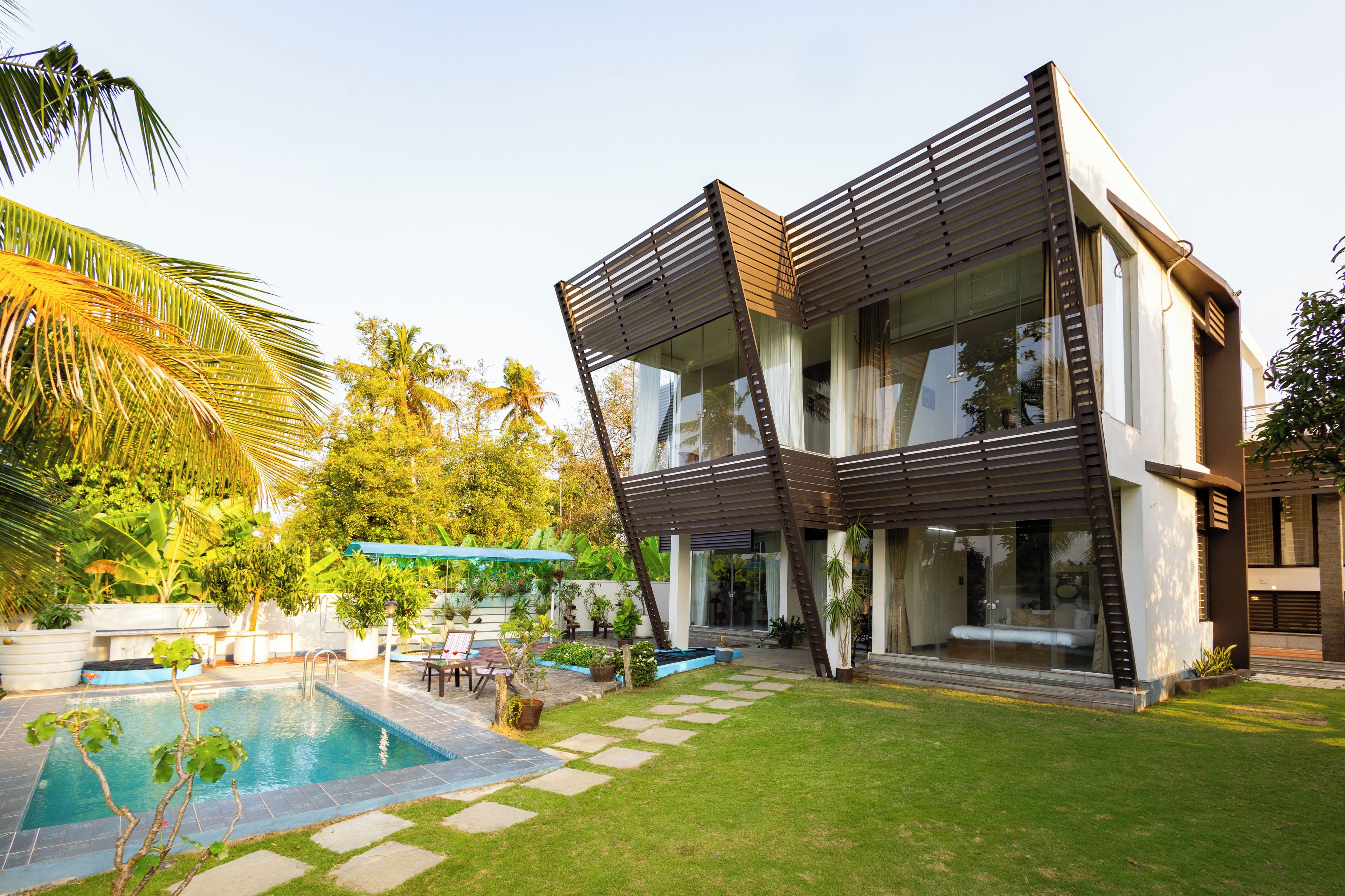 Una casa moderna con piscina, patio y jardín.