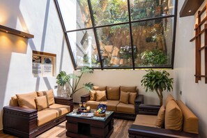 A modern living room with a large glass window, wooden furniture, and a small coffee table. - Glass River Retreat (Aluva)
