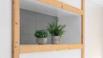 A wooden-framed mirror with two potted plants.