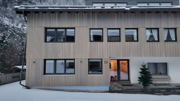 Un bâtiment moderne à deux étages, doté d’un toit plat, de nombreuses fenêtres et d’une petite entrée avec des marches.