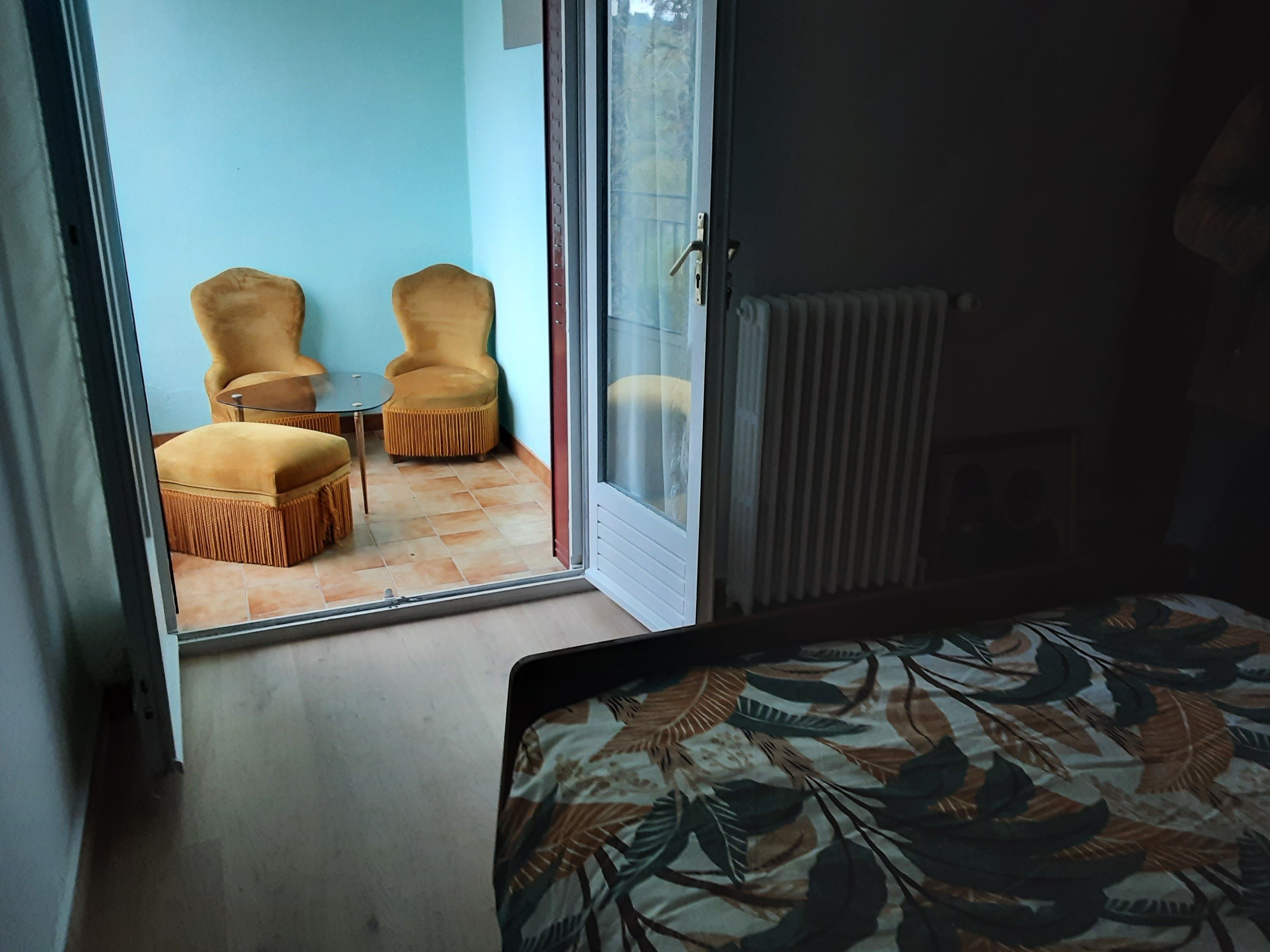 Een kamer met een bed, een stoel en een tafel.