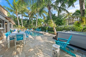 A poolside area with lounge chairs, a hot tub, and a stone patio. - The Coco Plum, Hot Tub, Island Living (West Palm Beach)