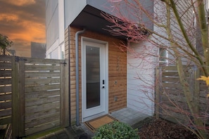 A modern house with a wooden door, a metal gate, and a small garden area. - Spacious Modern House Rooftop Backyard Loft 3B2.5B (Seattle)