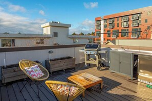 A rooftop deck with a grill, seating, and a view of buildings. - Spacious Modern House Rooftop Backyard Loft 3B2.5B (Seattle)
