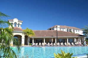 A hotel with a swimming pool, lounge chairs, and palm trees. - 3b/3.5b Vista Cay Resort - 5 min From Universal (Orlando)