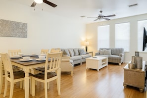 A spacious living room with a dining area, two sofas, a coffee table, and a TV. - 3b/3.5b Vista Cay Resort - 5 min From Universal (Orlando)