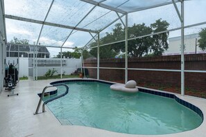 An indoor swimming pool with a clear roof, a diving board, and a floating ball. - 3BR Pool Home Near Disney in Kissimmee (Kissimmee)
