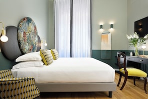 Een hotelkamer met een bed, een bureau, een stoel, een grote spiegel en een televisie.