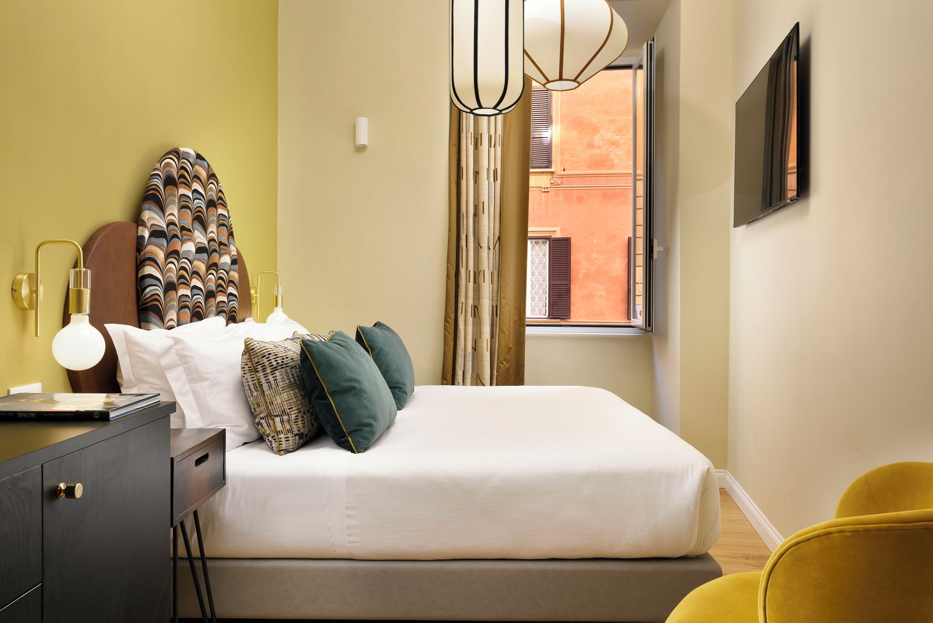 A neatly arranged bedroom with a bed, bedside table, lamp, and a window with curtains.