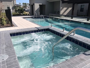A swimming pool with a hot tub area, surrounded by a tiled deck and a fence. - 3BR Terra Esmeralda Townhome, Free BBQ (Kissimmee)