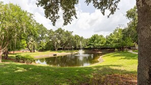 A park with a pond, trees, and a grassy area. - 3BR Lucaya Village Home Near Disney (Kissimmee)