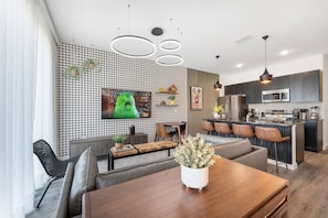A modern kitchen with a central island, built-in appliances, and pendant lighting. - 3BR Themed Home Near Disney (Kissimmee)