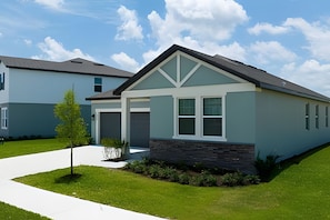 A modern two-story house with a garage, a front porch, and a well-maintained lawn. - 4BR West Haven Home, Lake View (Davenport)