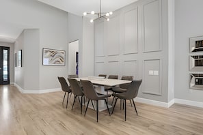 A modern dining room with a rectangular table, six chairs, and a contemporary chandelier. - Windsor Hills 5BR Luxury Pool & Game Room (Kissimmee)