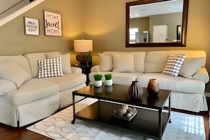 A living room with a sofa set, a coffee table, and decorative items. - 4BR Townhouse at Lucaya With Resort Pool (Kissimmee)