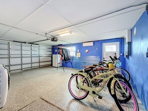 Ett garage med en blå vägg, ett vitt tak och ett cykelställ med en cykel.