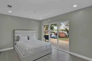 A bedroom with a large bed, a sliding glass door to the outside, and a ceiling with recessed lighting. - 5BR Lakeview Home w/ Pool 3min to Universal (Orlando)