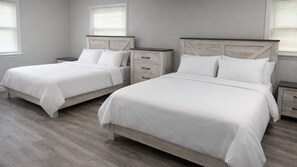 A bedroom with two beds, wooden headboards, white bedding, and a light-colored floor. - 4BR Lakefront Home w/ Dock & Private Views (Orlando)