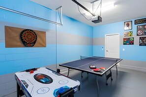 A room with a dartboard, ping pong table, and a foosball table. - Solterra Villa De Tommaso 5BR w Pool & Games (Davenport)