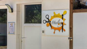Ein Gebäude mit einem Schild, das eine Sonne und Scheren zeigt und eine Friseursalon oder ein Friseurdienst anzeigt.