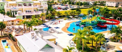 A resort with a swimming pool, water slides, and a covered area with lounge chairs.