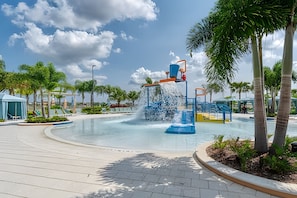 A water feature with a fountain and slides, surrounded by palm trees and a clear sky. - HMU - 1799 - Luxurious 7br/6ba Solara Resort (Kissimmee)