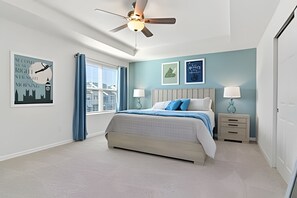 A bedroom with a bed, bedside tables, a ceiling fan, and artwork on the walls. - HMU - 1799 - Luxurious 7br/6ba Solara Resort (Kissimmee)