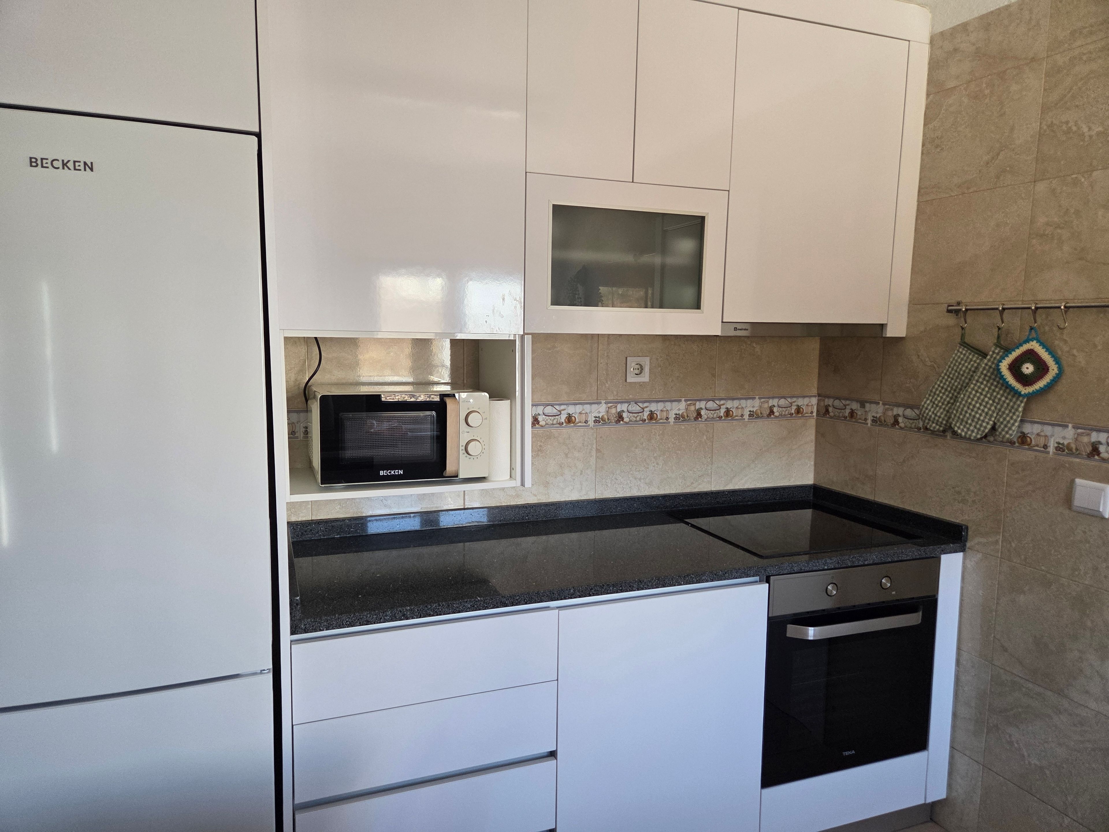 A kitchen with white cabinets, a microwave, a stove, and a dishwasher.