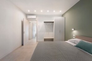 A bedroom with a bed, a wardrobe, a mirror, and a walk-in closet.