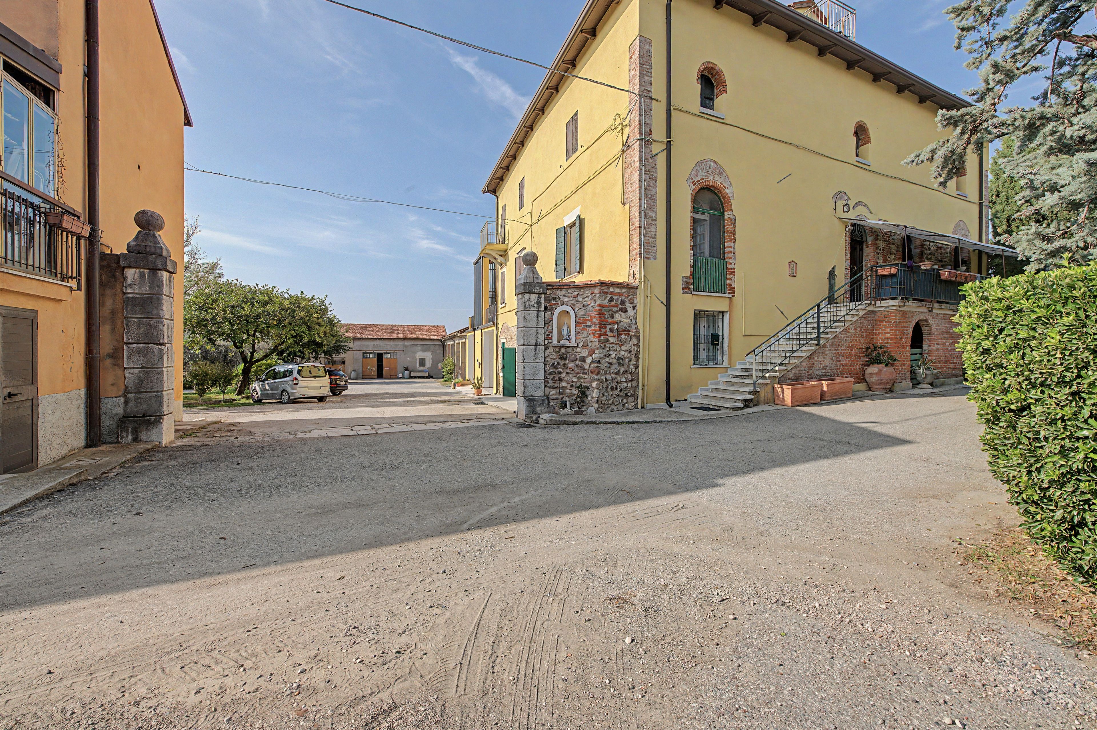 A street with buildings, a gravel road, and parked cars.