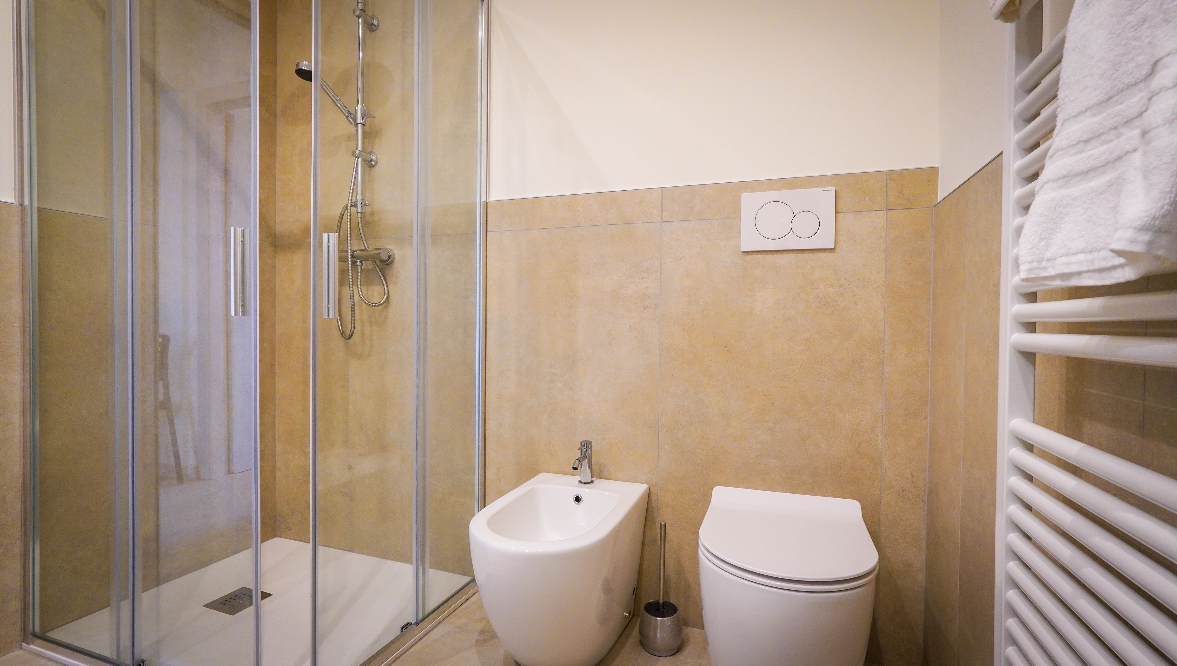 Une salle de bain avec une douche à parois de verre, un bidet et des toilettes.