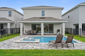 Propiedad residencial con piscina, mobiliario de patio y zona de estar exterior cubierta.