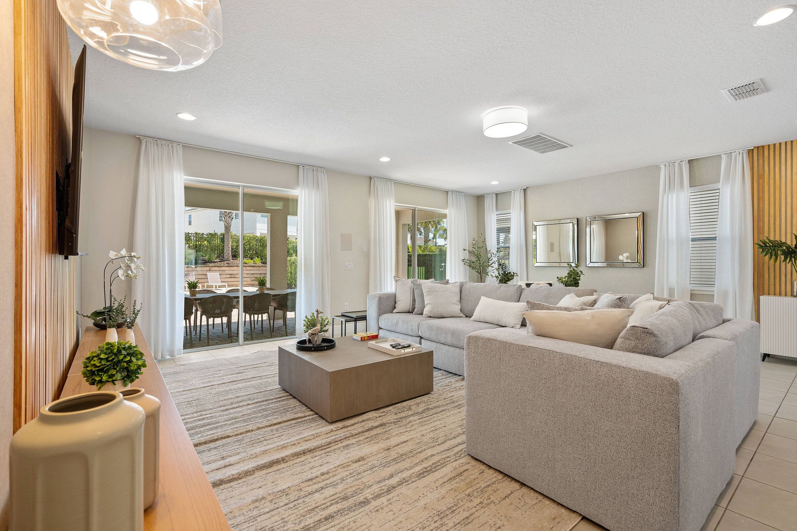 A modern living room with a sofa, coffee table, and a TV mounted on the wall.