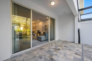 A modern interior with a sliding glass door leading to a patio area. - 3BR townhouse near Disney | Pool & Mickey room (Clermont)