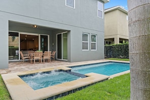 A residential property with a swimming pool, outdoor seating, and a covered patio area. - 6BR near Disney | Private pool, spa & loft (Kissimmee)