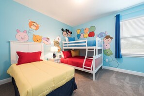 A child's bedroom with bunk beds, a bed with a red pillow, and cartoon character wall decals. - 5BR near Disney | Pool, spa & 2 living rooms (Kissimmee)
