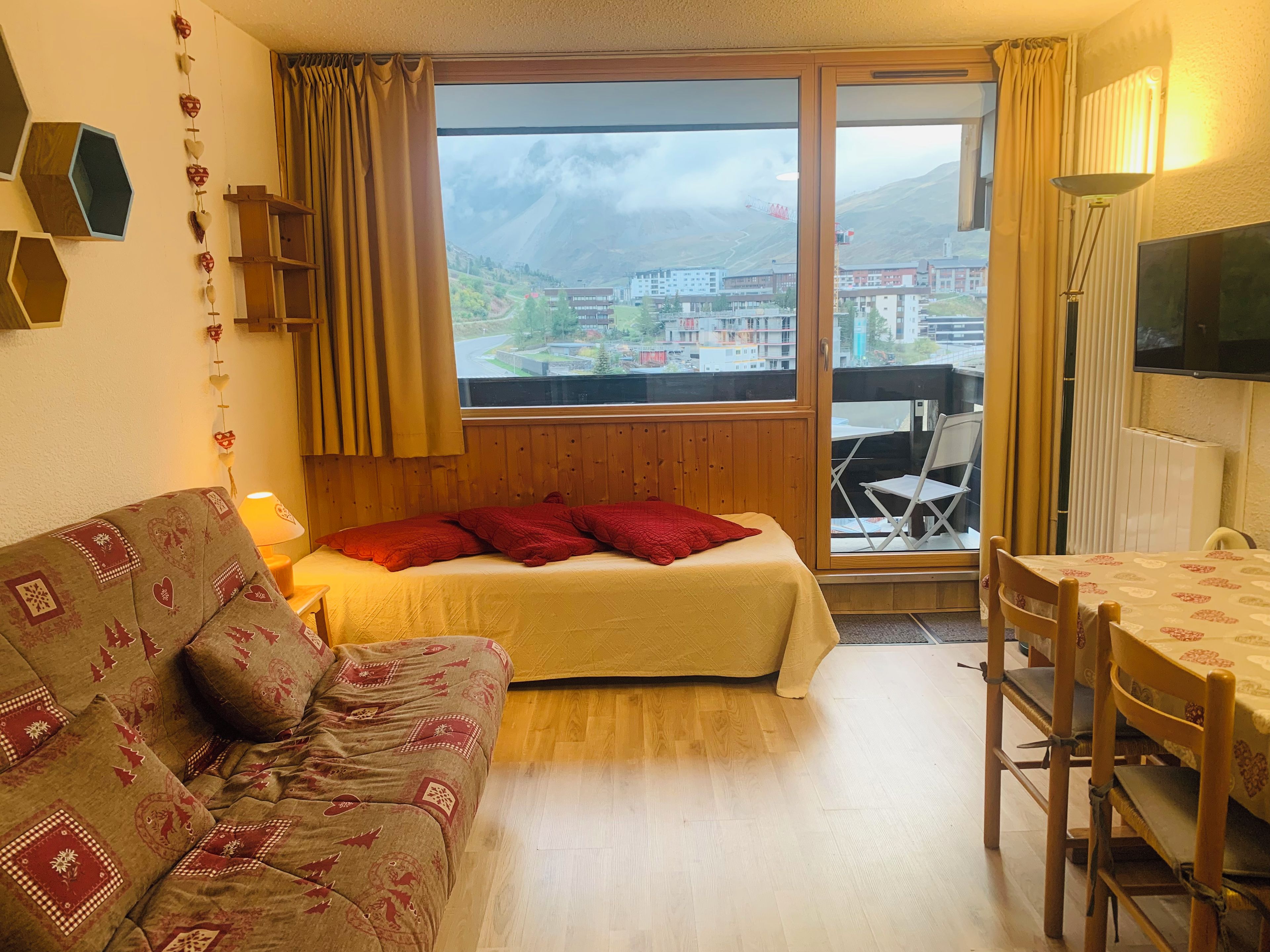 Una habitación con cama, sofá, mesa de comedor y televisor.