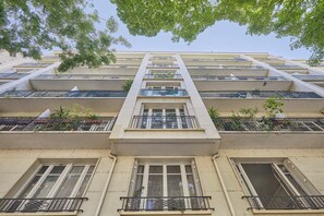A multi-story building with balconies, large windows, and a central entrance. - Bright Cosy Suite Paris 16th Steps from Seine (Paris)