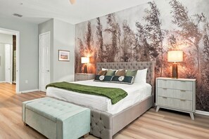 Ein Schlafzimmer mit Bett, Nachttischen, einer Tagesdecke in Grün und einem Wandgemälde.