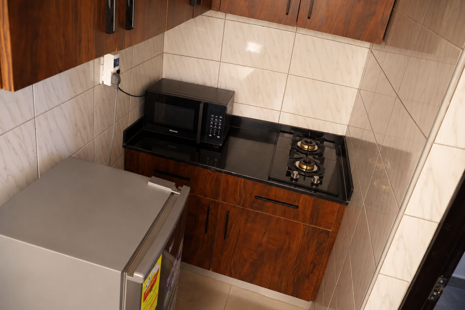 A compact kitchen with a microwave, stove, and refrigerator.