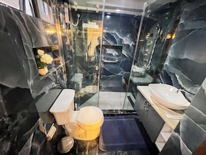 Ein Badezimmer mit einer Duschkabine, einer Toilette und einem Waschbecken.