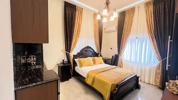 A hotel room with a bed, bedside table, and a desk with a chair.