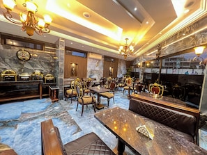 Eine Hotelhalle mit Marmorböden, aufwendigen Kronleuchtern und klassischer Möblierung.