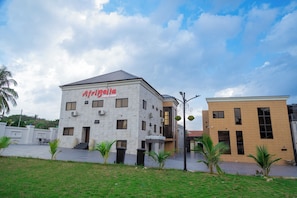 Edifici amb un rètol que diu 'AfriBella Luxury Suites' i un disseny modern amb nombroses finestres i un terrat pla.