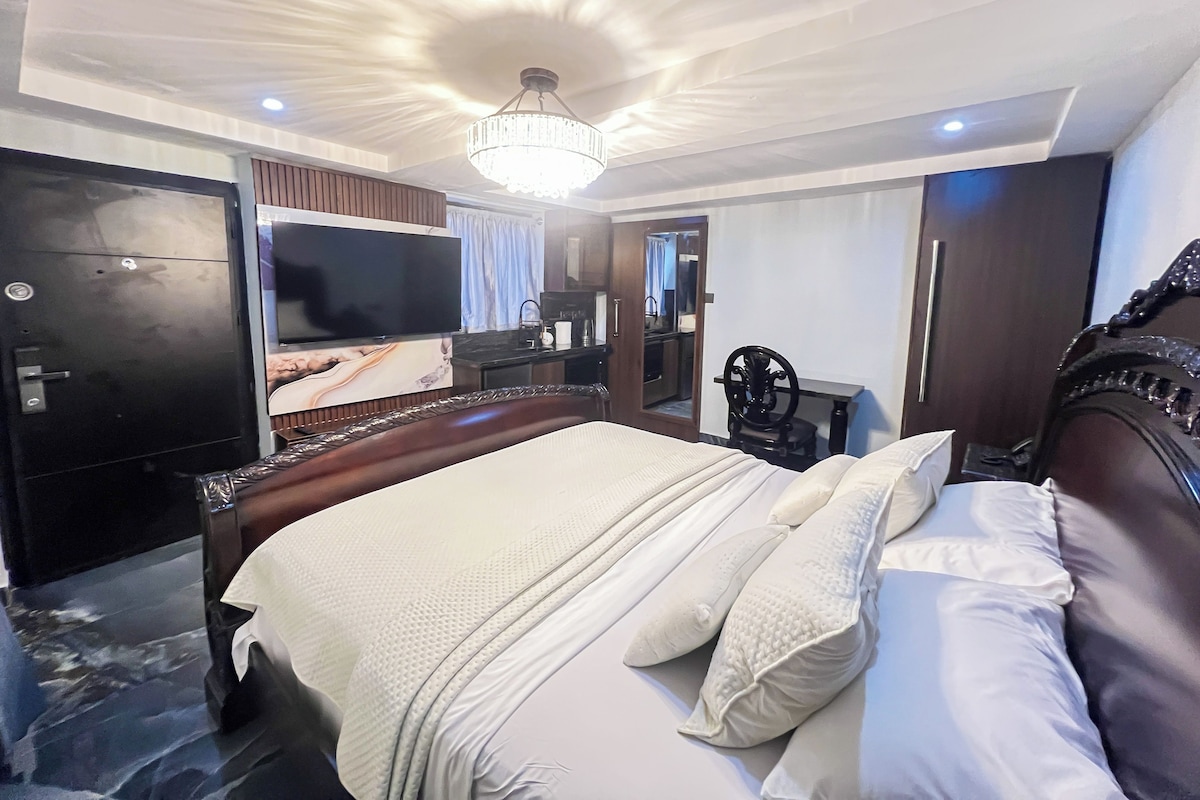 Ein Hotelzimmer mit einem großen Bett, einem Fernseher, einem Kleiderschrank und einem Spiegel.