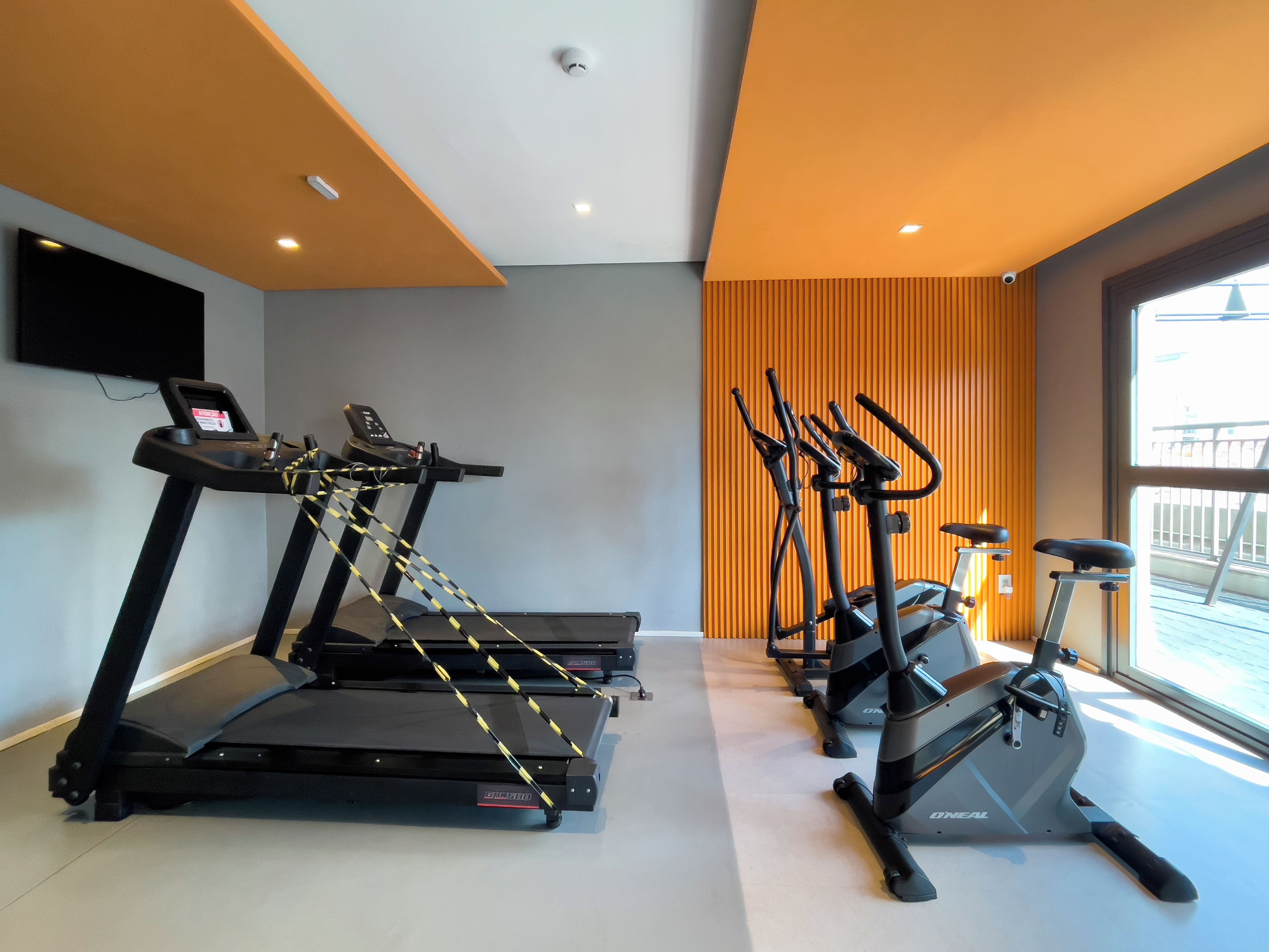A gym with treadmills, an elliptical, and a stationary bike, equipped with heart rate monitors.
