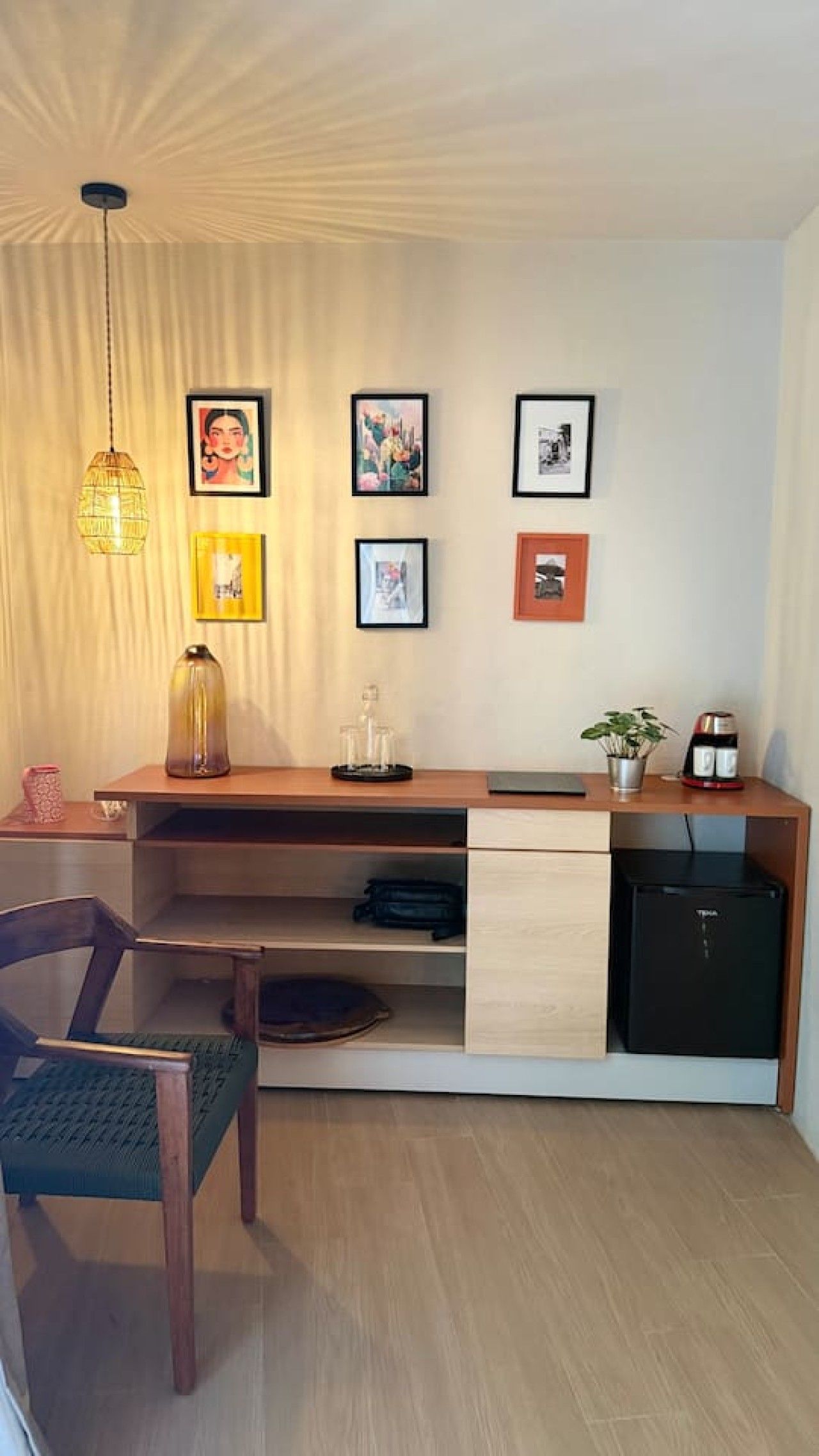 A modern kitchen with a built-in refrigerator, a coffee machine, and a dining area with a chair and table.
