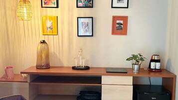 A modern kitchen with a built-in refrigerator, a coffee machine, and a dining area with a chair and table.